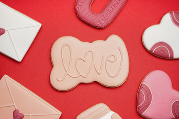 Different sweet cookies for Valentine's Day celebration on red background, closeup