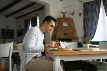 one young man sit at table eat burger and chips at restaurant