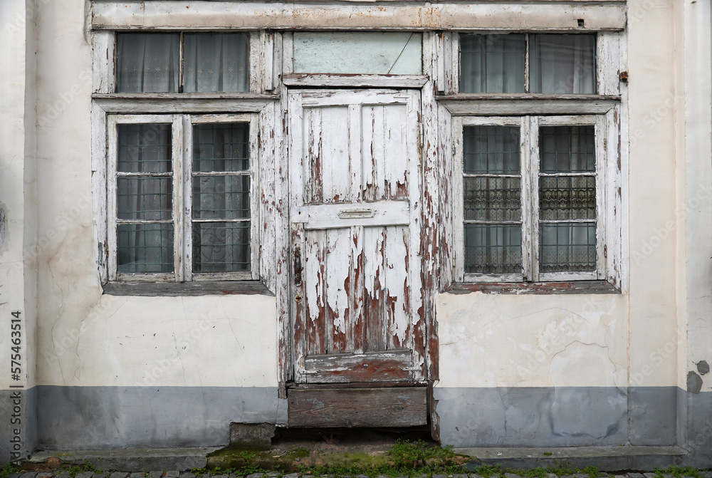 Wall mural old painted wooden door between two windows