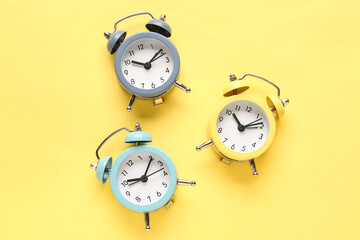 Fototapeta na wymiar Alarm clocks on yellow background