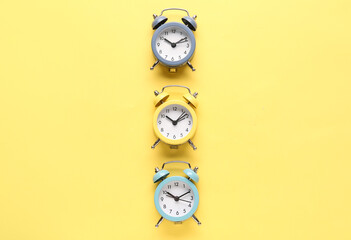 Alarm clocks on yellow background