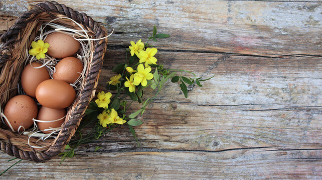 Background easter. A basket with eggs stands on a wooden rustic background. Copy space. Flat Lay.