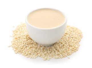 Ceramic bowl of tasty tahini and sesame seeds on white background