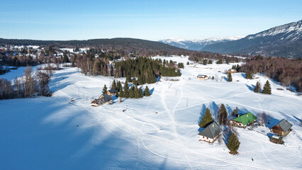 Panoramic view of snowy mountains in winter. Foggy mountains. Woods in front of the mountains. Mountains resort station.