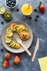 Caterpillar shaped keto diet pancakes served with fruit and juice.