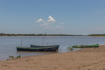 Obraz premium Three canoes moored on the river bank.