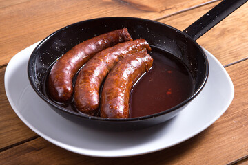 Delicious fried sausages in iron pan