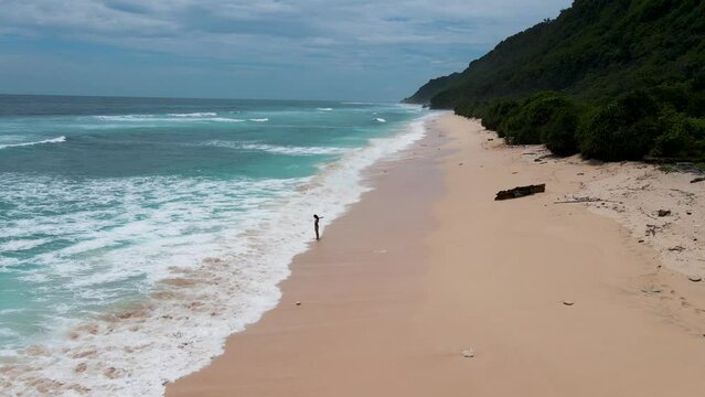 woman girl alone on the beach video freedom happiness feeling tropical wild beach Bali crystal water waves drone aerial top view heavenly paradise place