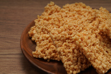 A plate of crispy rice is on the wooden table