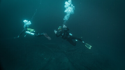 technical diving instructor, guides a tourist and he makes an ok signal in cenote angelita