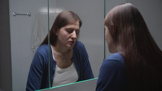 Upset woman standing at sink and thinking of her problems and depression. Concept of depression, stress, mental illness and problems, loneliness and frustration
