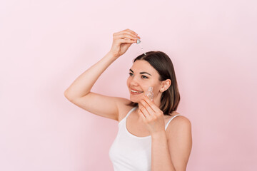 Fototapeta premium Lady drips oil with a pipette on her parting on her head.