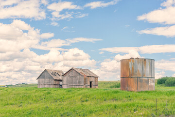 Two Abandoned Sheds and Grain Silo in Summer