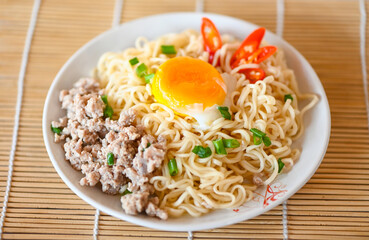 noodles plate with boiled egg minced pork vegetable spring onion and chili on table food , instant noodles cooking tasty eating with plate noodle