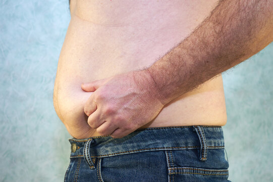a man in jeans with a bare torso and a small belly close-up of the concept of overweight body positive