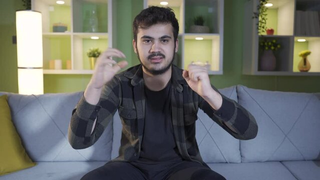 Positive young man giving motivational and pep talk at home.
Strong and brave young man at home giving motivation and moral support to camera.
