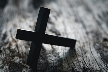 A wooden Christian cross crucifix on a grunge board background. Wooden Christian cross on grey...