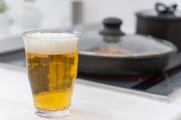 キッチンで料理をしながらビールを飲む