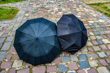 Blaсk umbrella on the floor wet after rain.