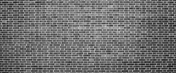 Grayscale backdrop with old realistic black brick wall. Minimal fragment of brickwall close-up....
