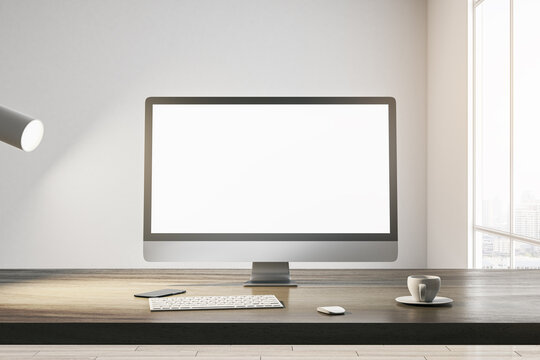 Front view on blank white modern computer monitor with place for your web site or web design on wooden table with coffee cup and keyboard on light wall background in sunlit room. 3D rendering, mock up