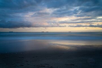 Fototapeta na wymiar Papamoa ocean beach moody dark after storm