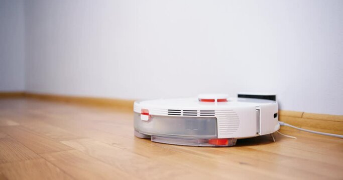 Robot vacuum cleaner performs automatic cleaning of the house at a certain time. Smart home concept. Copy space
