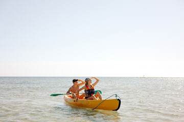 a woman and a man on a kayak in the sea