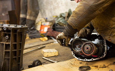 repair of car gearbox mechanisms in a car service in the garage.