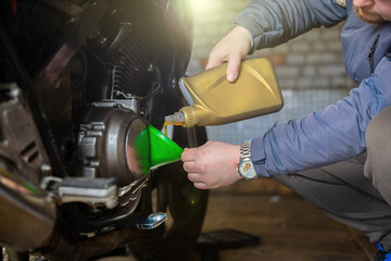 pouring new engine oil into a motorcycle engine.