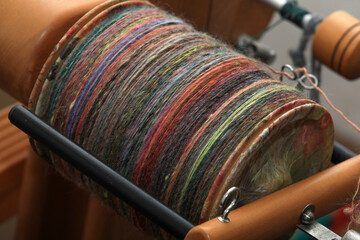 Closeup detail of colourful organic natural handspun and handdyed merino sheep wool yarn , spun on a traditional spinning wheel - obrazy, fototapety, plakaty