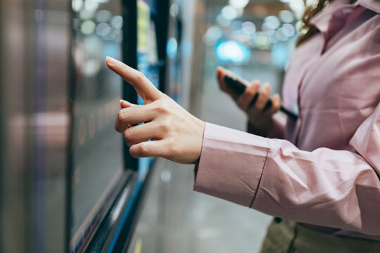 Businesswoman Buying Tickets At Ticket Machine At Train Or Subway Station