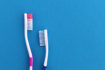 Several multi-colored toothbrushes lie on a blue background
