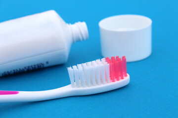 Toothpaste with a brush is on a blue background.	