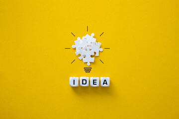 Light bulb from puzzles on yellow background.