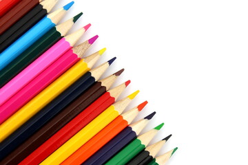 Bright colored pencils lie on a white background with space for text.