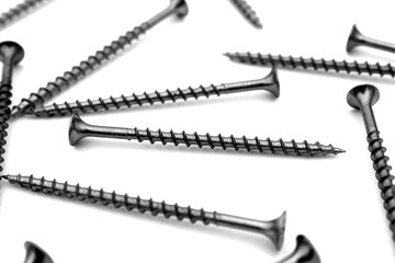 A lot of self-tapping screws lie on a white isolated background.	