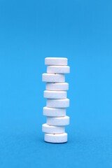 On a blue background, there are a lot of pills in a column.	