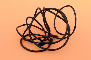 A crumpled cord lies on an orange background.