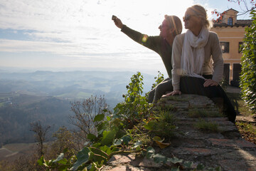Mature couple take selfie on town wall