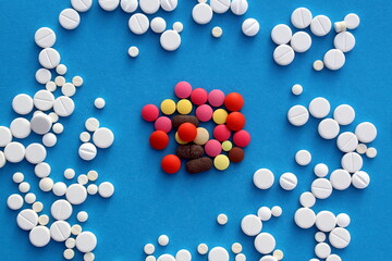 Background from different bright pills on a blue background, top view.