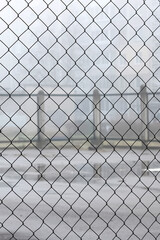 Fence net against backdrop of playground for games in fog