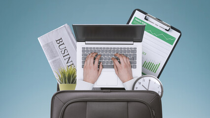 Obraz na płótnie Canvas Businessman and office equipment in a briefcase