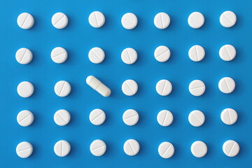 Abstract background of white pills on a blue background.