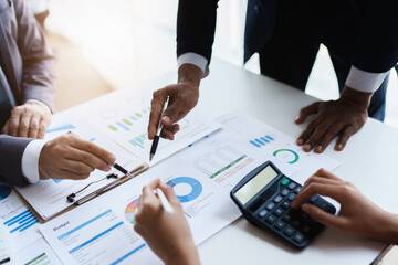 Team business adviser meeting to analyze and discuss the situation on the financial report n the meeting room with using calculator, documents, computer laptop in work.