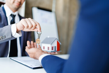 Fototapeta na wymiar Real estate company to buy houses and land are delivering keys and houses to customers after agreeing to make a home purchase agreement and make a loan agreement.