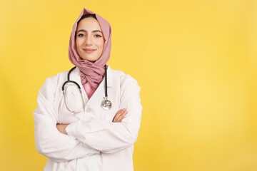 Happy female muslim doctor with arms crossed looking at camera