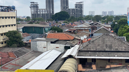 A view of jakarta slum house roof with abandoned building on background