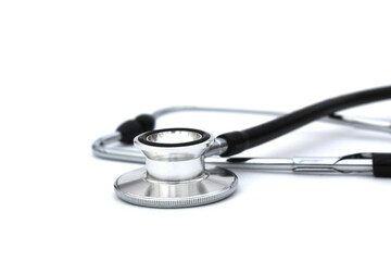 On a white isolated background lies a black stethoscope.