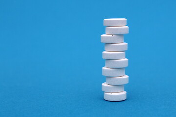 Fototapeta na wymiar On a blue background, there are a lot of pills in a column.